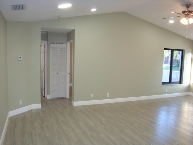 unfurnished room with lofted ceiling, light hardwood / wood-style floors, and ceiling fan