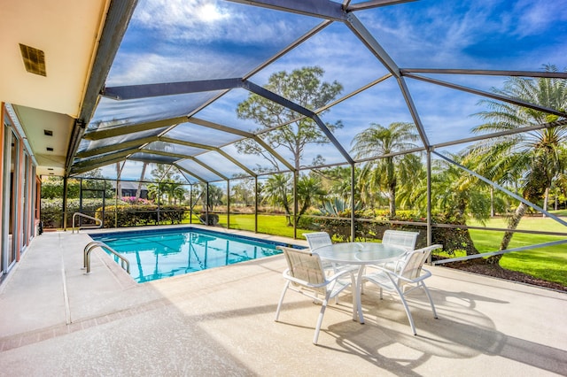 view of pool with a lanai, a patio area, and a lawn