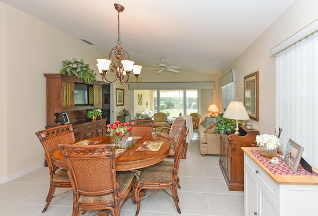 tiled dining area featuring lofted ceiling and ceiling fan with notable chandelier