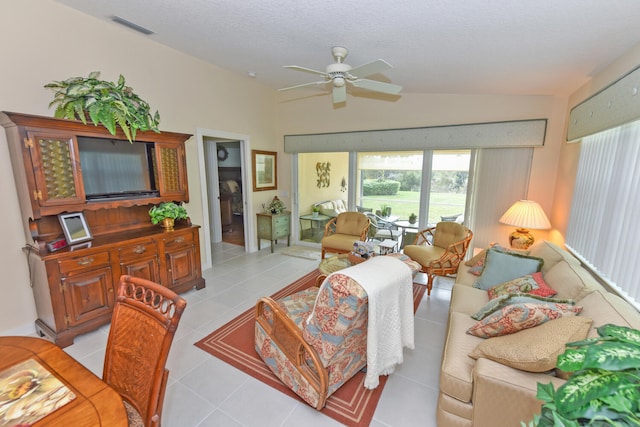 tiled living room featuring ceiling fan, vaulted ceiling, and a textured ceiling