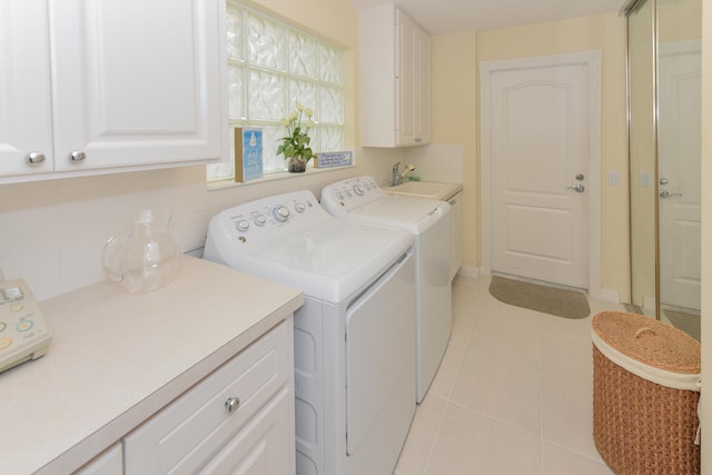 laundry room featuring cabinets, light tile patterned flooring, sink, and washing machine and clothes dryer