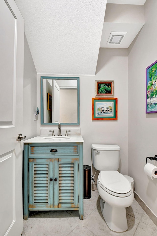 bathroom with visible vents, toilet, vanity, tile patterned flooring, and baseboards