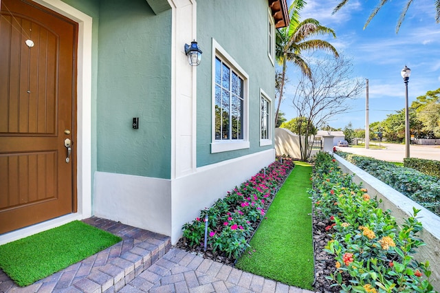 property entrance featuring fence and stucco siding