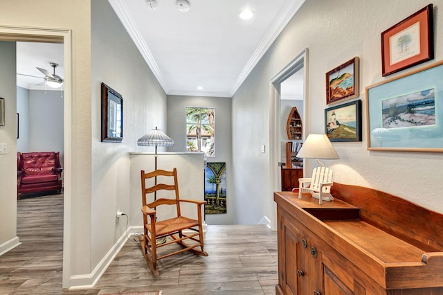 living area featuring ceiling fan, crown molding, baseboards, and wood finished floors