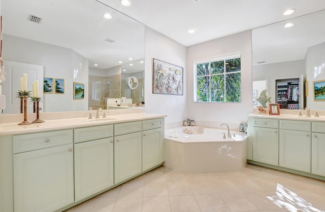 full bath featuring a garden tub, a shower stall, visible vents, and a sink