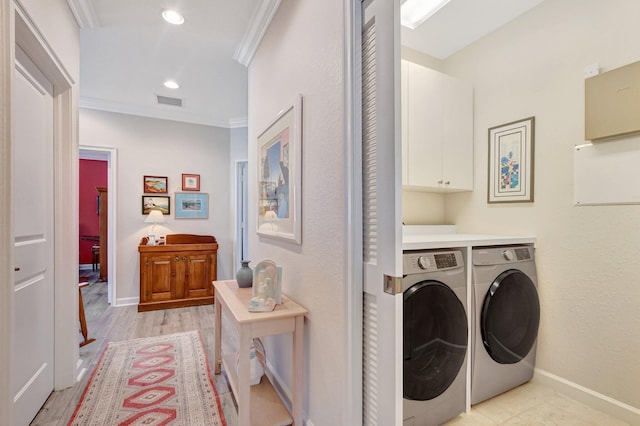 laundry room with baseboards, cabinet space, crown molding, and washing machine and clothes dryer