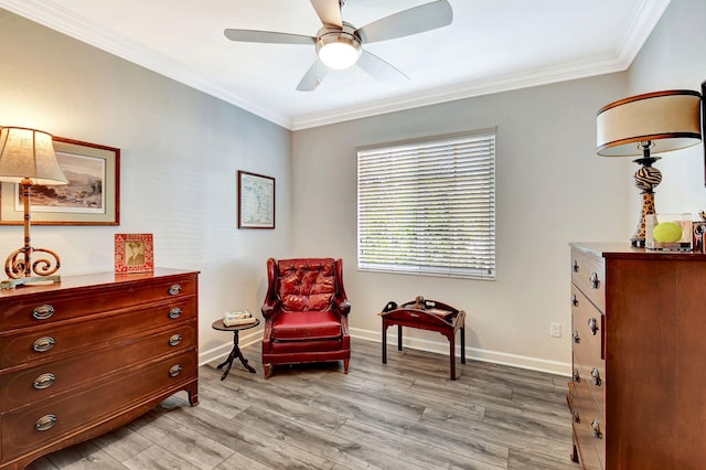 sitting room with ornamental molding, light wood finished floors, a ceiling fan, and baseboards