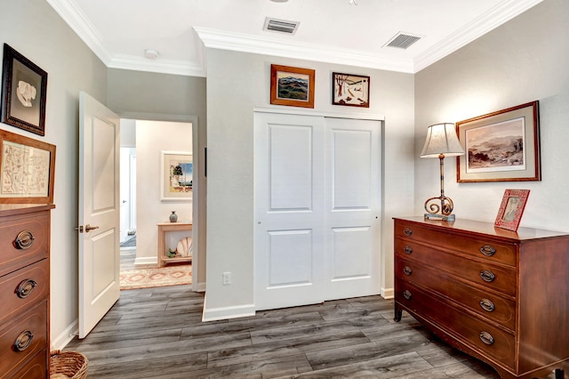 bedroom featuring visible vents, dark wood finished floors, a closet, and ornamental molding