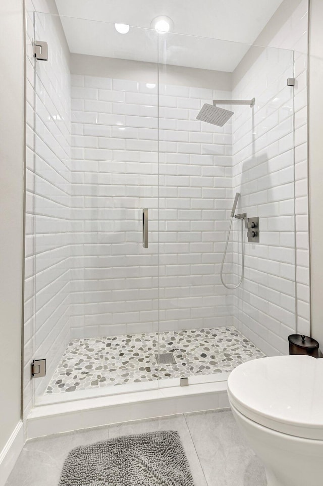 bathroom with a shower stall and toilet