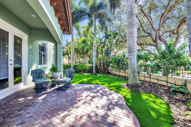 view of patio / terrace featuring fence and french doors