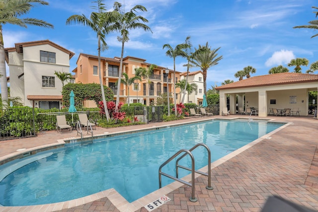 community pool featuring fence and a patio