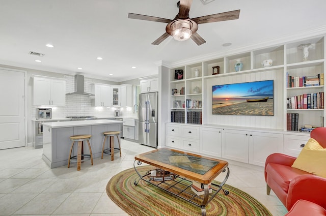 living area with crown molding, recessed lighting, visible vents, light tile patterned flooring, and ceiling fan