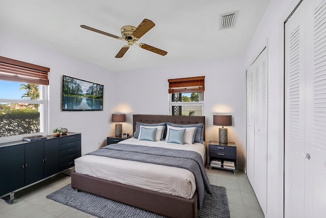 bedroom featuring a ceiling fan, light tile patterned floors, and visible vents