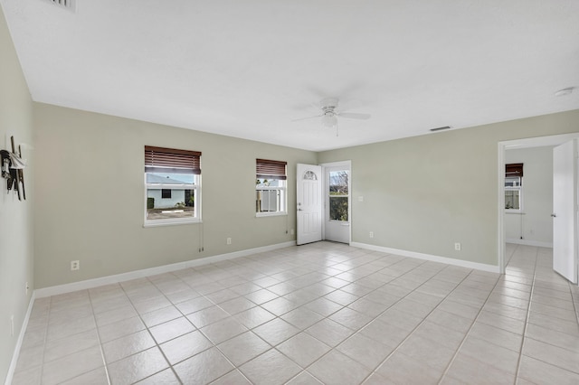 unfurnished room with baseboards, ceiling fan, visible vents, and light tile patterned floors