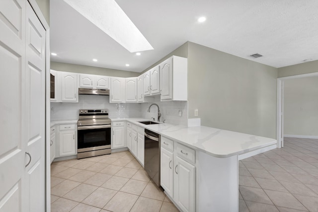 kitchen featuring under cabinet range hood, electric stove, light tile patterned flooring, a skylight, and dishwashing machine