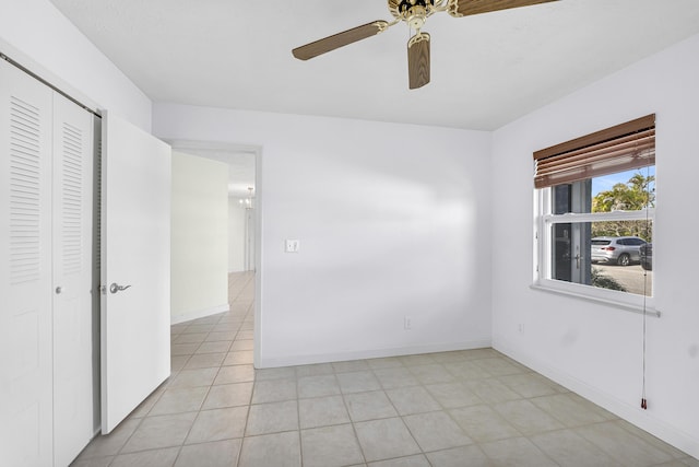 unfurnished room featuring light tile patterned floors, baseboards, and a ceiling fan