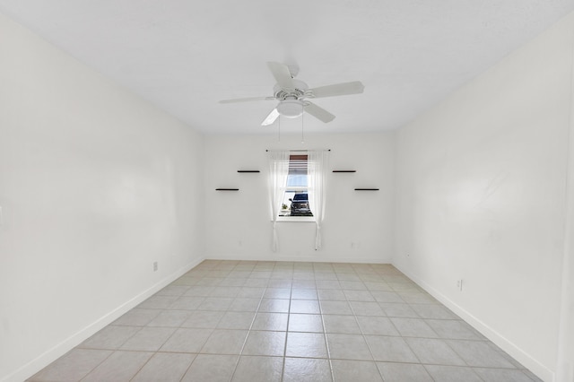 empty room featuring baseboards, ceiling fan, and light tile patterned flooring