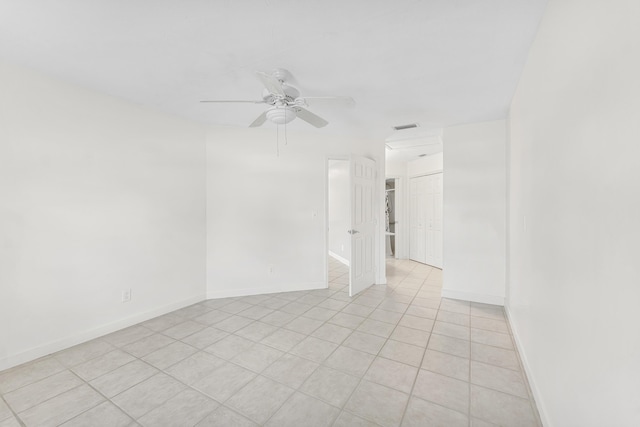 spare room featuring visible vents, baseboards, light tile patterned flooring, and ceiling fan