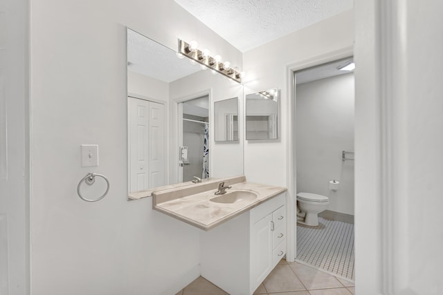 full bathroom with tile patterned floors, toilet, a sink, and a textured ceiling