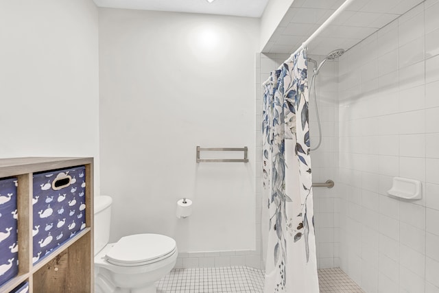 full bathroom featuring toilet, tile patterned flooring, and a tile shower