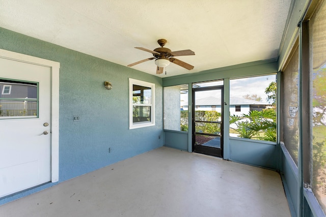 unfurnished sunroom with a ceiling fan