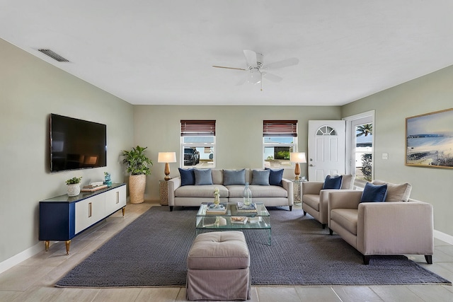 living room featuring a ceiling fan, baseboards, and visible vents