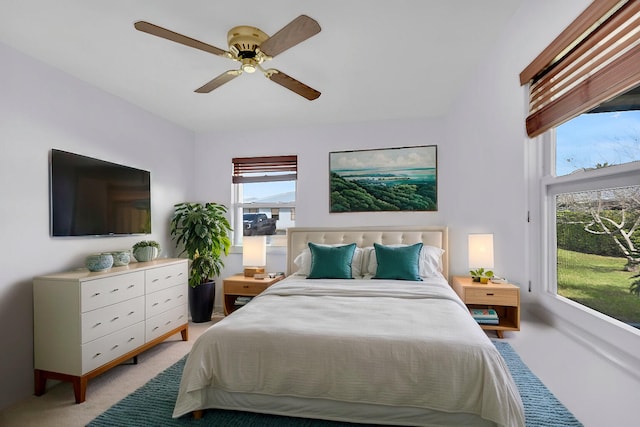 bedroom featuring light carpet and a ceiling fan