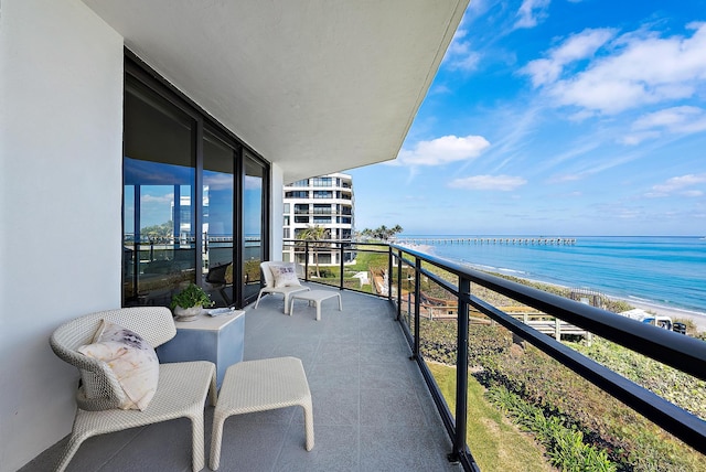 balcony featuring a water view and a view of the beach