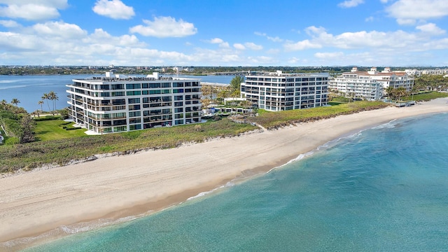 birds eye view of property with a water view and a beach view