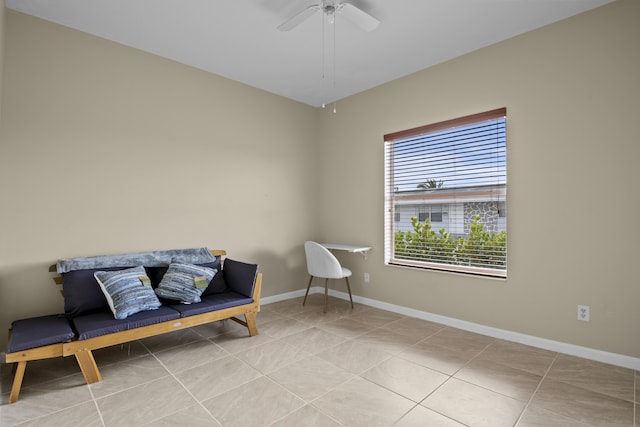 sitting room featuring tile patterned floors, baseboards, and ceiling fan