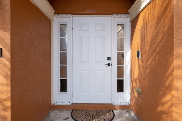 entrance to property featuring stucco siding