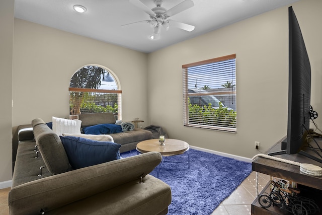 living area with tile patterned flooring, baseboards, and ceiling fan