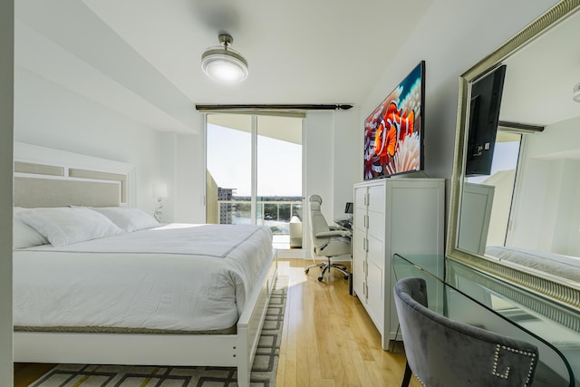 bedroom with floor to ceiling windows and light hardwood / wood-style flooring