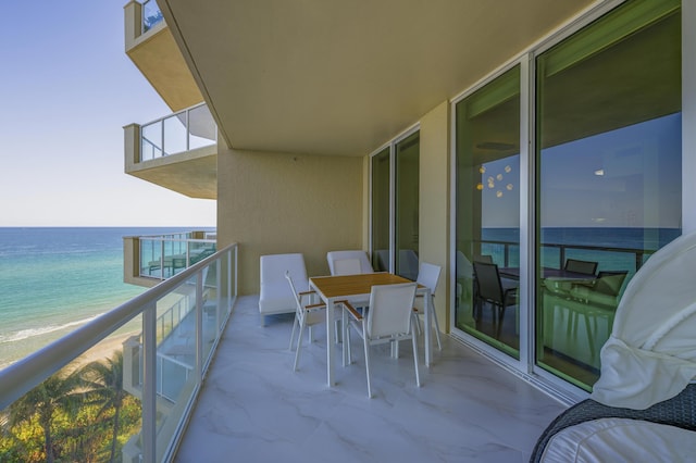 balcony featuring a water view and a beach view