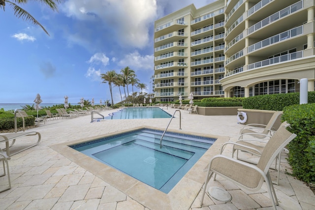 view of pool with a hot tub and a patio area