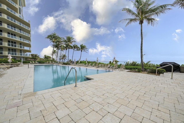 view of pool featuring grilling area and a patio