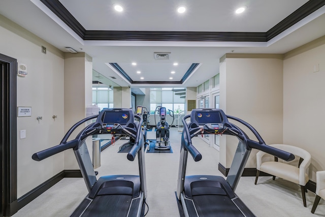 gym with crown molding and a tray ceiling