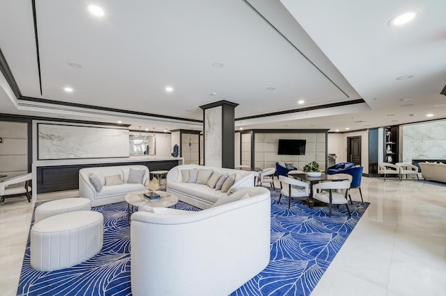 living room featuring ornamental molding, a raised ceiling, and decorative columns