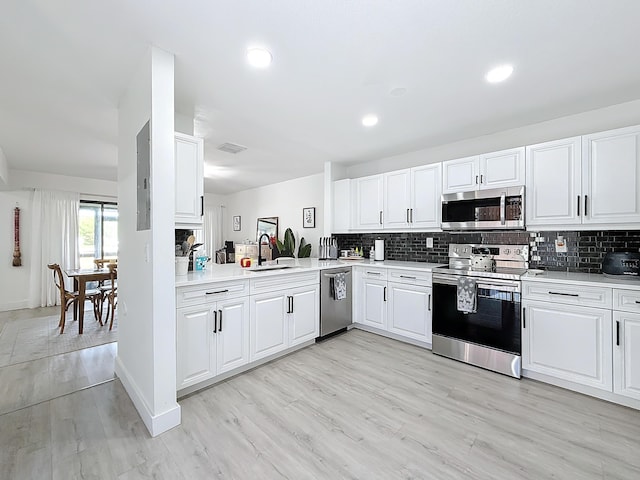 kitchen with white cabinetry, sink, tasteful backsplash, and stainless steel appliances