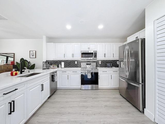 kitchen featuring stainless steel appliances, sink, white cabinets, and backsplash