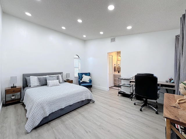 bedroom with a textured ceiling and light wood-type flooring