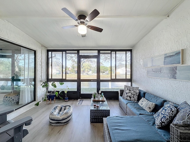 sunroom / solarium with wood ceiling, ceiling fan, and lofted ceiling