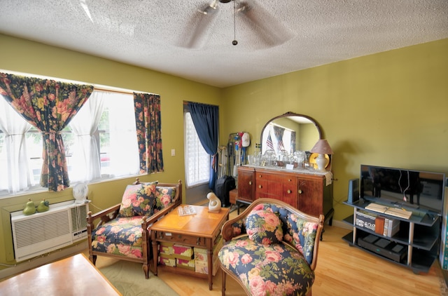 sitting room featuring ceiling fan, a textured ceiling, and light hardwood / wood-style flooring