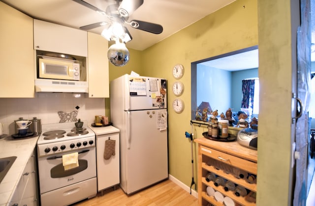 kitchen with tasteful backsplash, light hardwood / wood-style flooring, ceiling fan, white appliances, and white cabinets