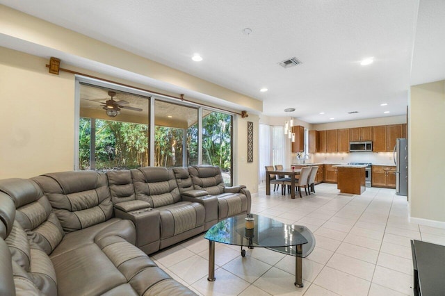 tiled living room with sink and a textured ceiling