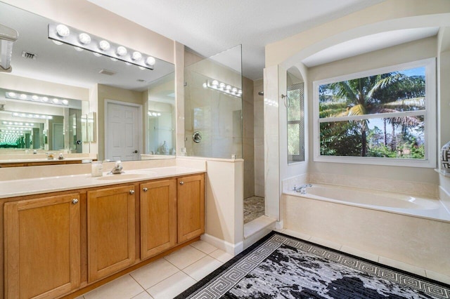 bathroom featuring tile patterned flooring, vanity, and shower with separate bathtub