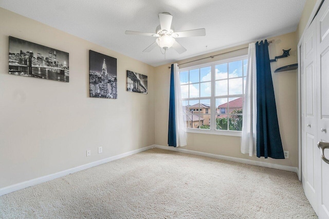 empty room featuring carpet floors, a textured ceiling, and ceiling fan