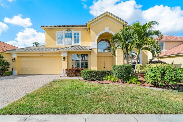 mediterranean / spanish-style house with a garage and a front yard