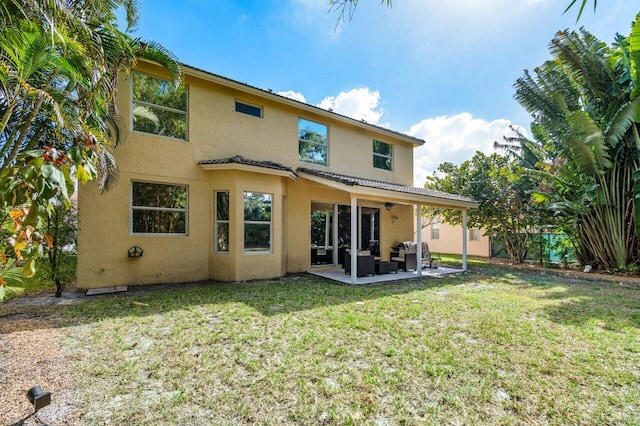 rear view of property featuring an outdoor hangout area, a lawn, ceiling fan, and a patio area