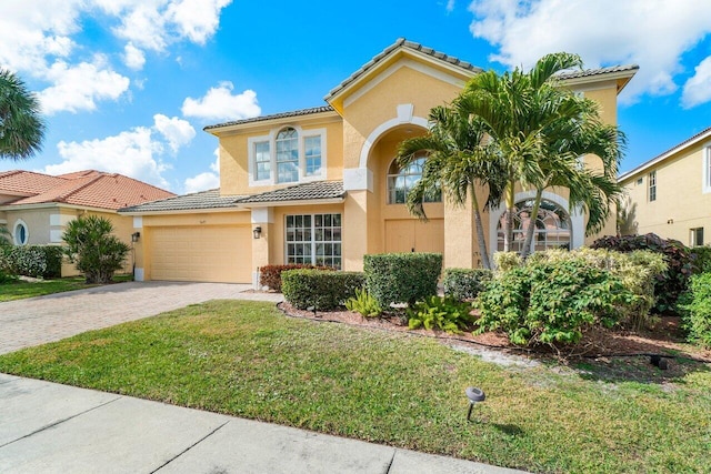 mediterranean / spanish-style house with a garage and a front lawn